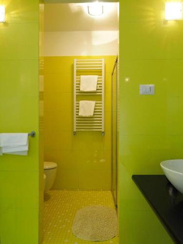 a green bathroom with a sink and a toilet at appartamento da detta in Vernazza
