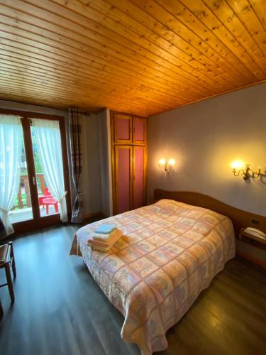 1 dormitorio con 1 cama grande y techo de madera en Le Chalet en Luttenbach-près-Munster