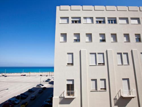 
a large white building sitting on top of a beach at Hotel Vittoria in Trapani
