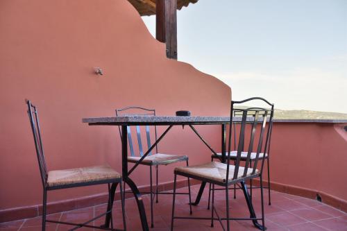 tavolo e sedie in una stanza con parete di Casa Mare Cala Rossa a Trinità dʼAgultu