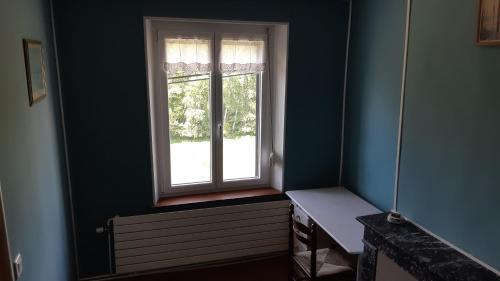 a window in a blue room with a bench next to it at Les Hauts de Proisy in Proisy