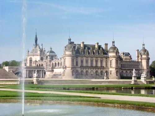 a large castle with a fountain in front of it at ibis Senlis in Senlis