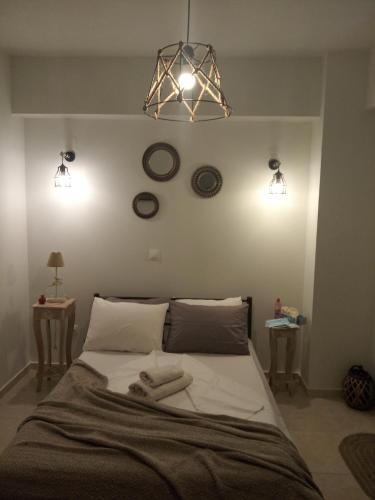 a bedroom with a bed with two clocks on the wall at DORA'S APARTMENTS STUDIO 1 in Corfu