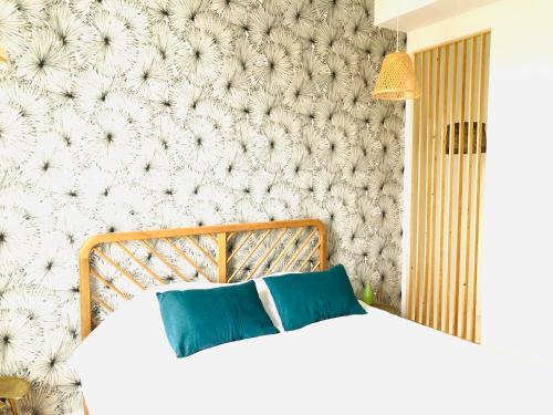 a bedroom with a white bed with blue pillows at Maison BB Burgonce Bohème centre avec extérieur WIFI gratuit et NETFLIX in Niort