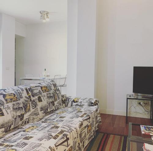 a bed in a room with a couch and a tv at Apartamento de Lujo I en Madrid Centro in Madrid