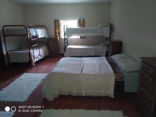 a bedroom with two bunk beds and a couch at Stone Farm Hostel in Felgueiras