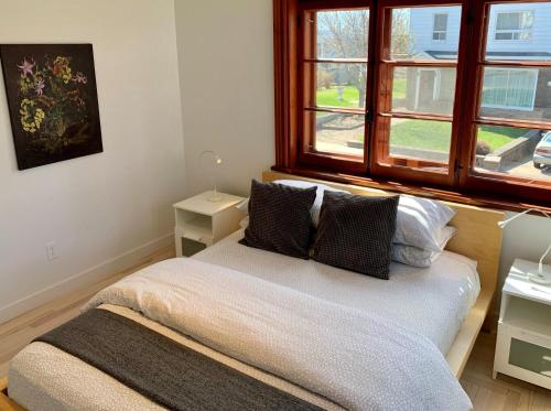 1 dormitorio con cama con almohadas y ventana en Appartements Gite Kezako, en Lévis