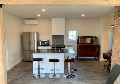 a kitchen with a counter and some bar stools at Appartements Gite Kezako in Lévis