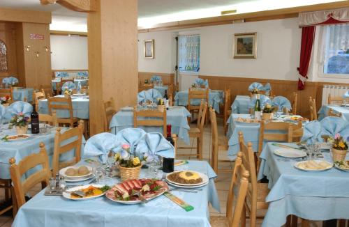 une salle à manger avec des tables et des chaises bleues dans l'établissement Hotel La Roccia, à Passo del Tonale