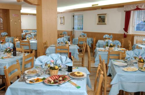a dining room with blue tables and chairs at Hotel La Roccia in Passo del Tonale