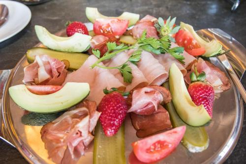 a plate of food with meat and fruit on a table at White Lion Lodge on Sanbona in Montagu