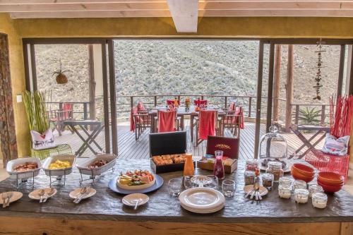 a table with plates of food on a balcony at White Lion Lodge on Sanbona in Montagu