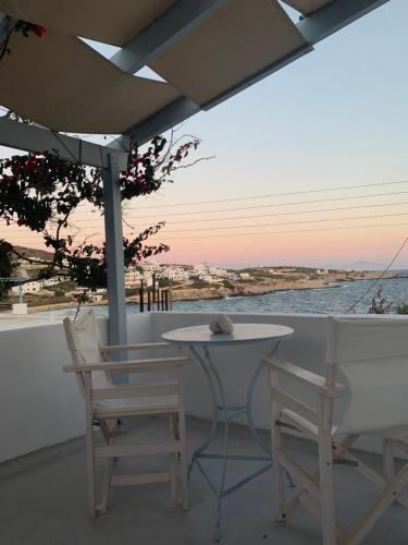 a table and chairs on a balcony with the ocean at Astrofegia guest house in Donoussa