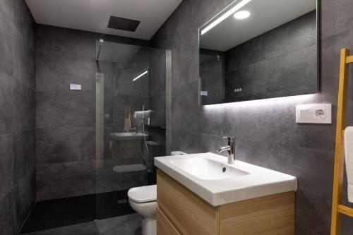 uma casa de banho com um lavatório, um WC e um espelho. em Suite Nest em Padrón
