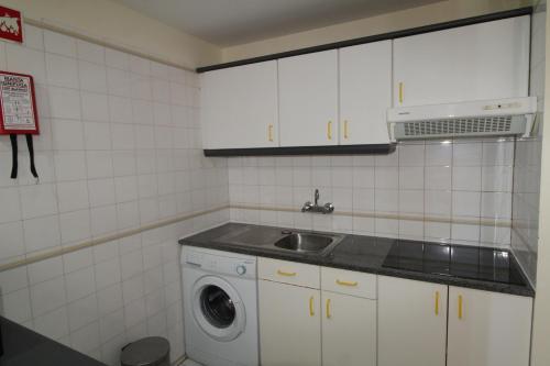 a kitchen with a sink and a washing machine at ApartamentoSolPraia - VilaRosa in Portimão