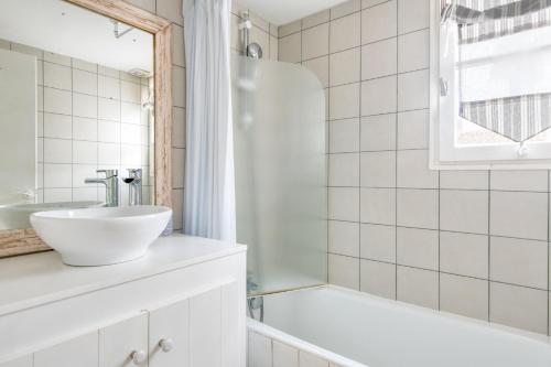 y baño blanco con lavabo y bañera. en Appartement Liseron, en Saint-Martin-de-Ré
