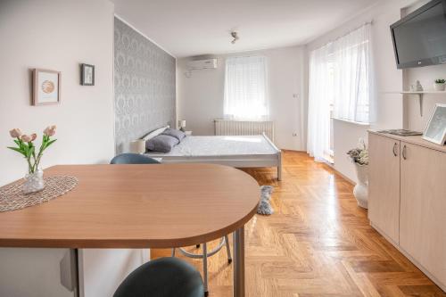 a living room with a bed and a table at Stella Modern Apartment 2 in Novi Sad
