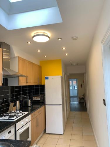 a kitchen with a white refrigerator and a stove at Grand Heights Suites in London