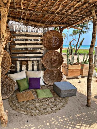 an outdoor bed with pillows and a table with the beach at Memo's Beach in Nilaveli