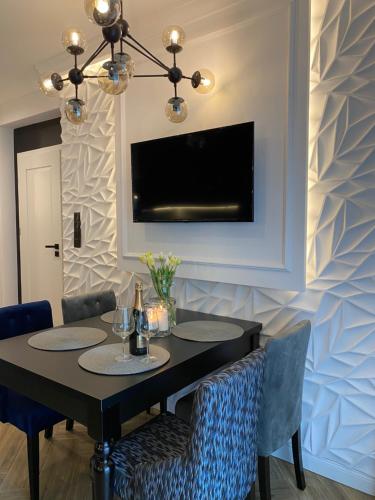 a dining room with a black table and chairs at Family & Business Sauna Apartments No 6 Leśny nad Zalewem Cedzyna - 1 Bedroom with Private Sauna, Terrace, Parking, Catering Options in Kielce