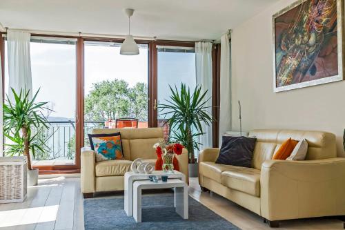 a living room with two couches and a table at Panoramic Art Apartment with jacuzzi in Balatonlelle