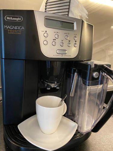 a coffee maker with a cup on a plate at Family & Business Sauna Apartments No 6 Leśny nad Zalewem Cedzyna - 1 Bedroom with Private Sauna, Terrace, Parking, Catering Options in Kielce