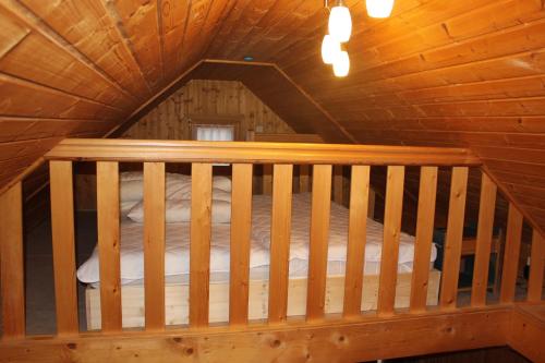 Habitación con cama en una cabaña de madera en Ferienhaus am Zainhammer, en Brotterode