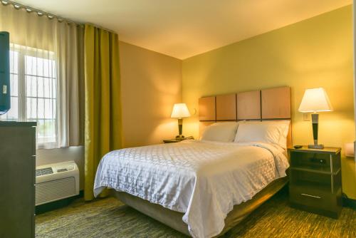 A bed or beds in a room at Candlewood Suites Medford, an IHG Hotel
