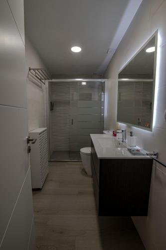 a bathroom with a sink and a toilet and a mirror at Casa Jordi in Valderrobres