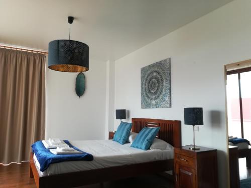 een slaapkamer met een bed met blauwe kussens bij DaLagoa Charm Villa Pool Beach in Vau