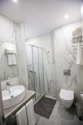 a bathroom with a sink and a toilet and a shower at Stella boutigue rooms in Nea Peramos