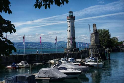 a lighthouse and boats docked in a harbor at Gästezimmer Hozici in Lindau