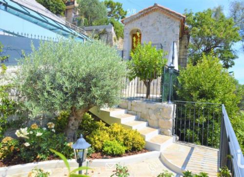 a house with a staircase in front of a house at Villa d exception avec terrasse, jacuzzi, vue mer, parking, en plein cœur du village de Eze in Éze