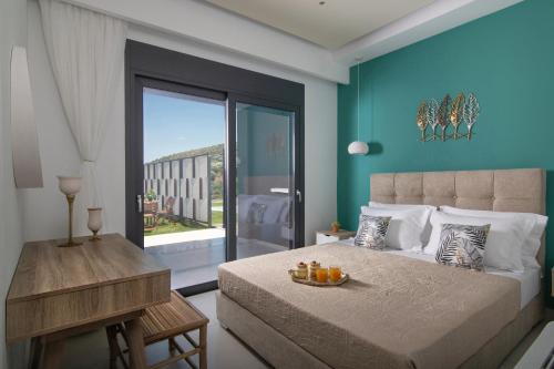 a bedroom with a bed with a blue wall at Chrisanthi Villas in Palaiokastro