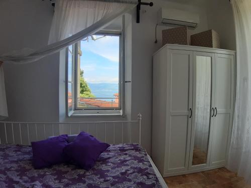 a bedroom with a bed and a window at APARTMENT PALAZZO ŠARE in Vrbnik