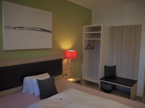 a bedroom with a bed and a chair and a desk at Hotel „Zur Linde“ in Ehingen