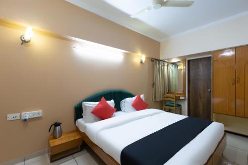 Un dormitorio con una cama grande con almohadas rojas. en Hotel Foliage, en Jamnagar