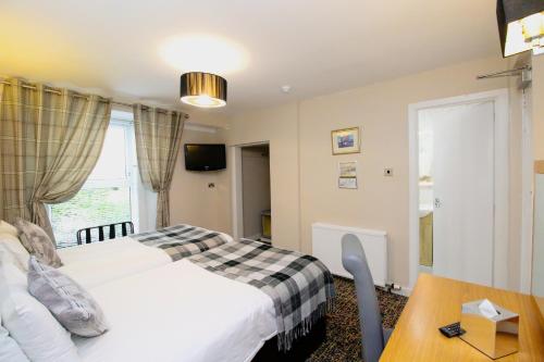 a hotel room with a bed and a table at Kelvingrove Hotel - Sauchiehall St in Glasgow