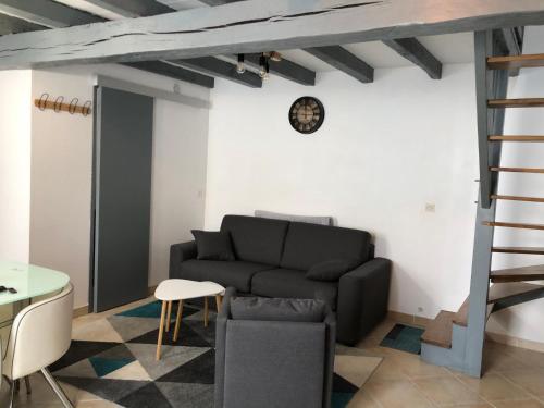een woonkamer met een bank en een tafel bij Petite maison tout confort in Esnandes