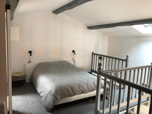 1 dormitorio con cama y escalera en Petite maison tout confort en Esnandes