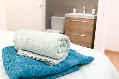 a pile of towels sitting on top of a bed at SUITE PLAYA Y MAR - sea view, wifi and AC in Melenara