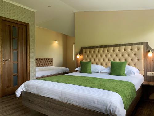 a hotel room with two beds with green pillows at Idylia Grand Villas in Migovo