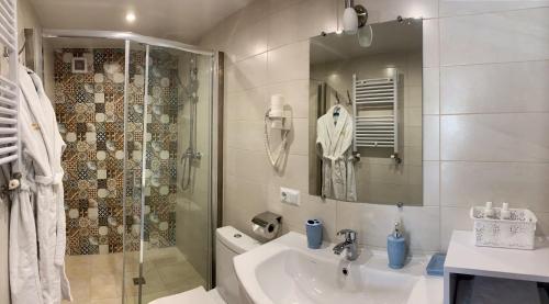 a white bathroom with a sink and a shower at Idylia Grand Villas in Migovo