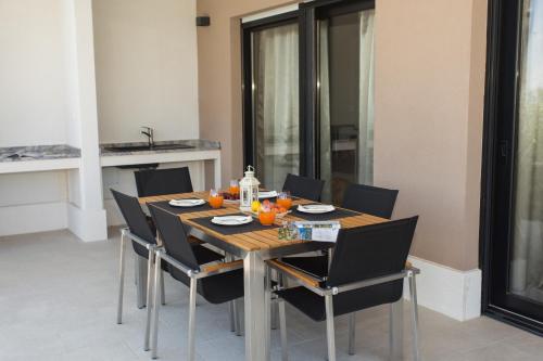 a dining room table with chairs and orange juice on it at View Villas Collection in Vinišće