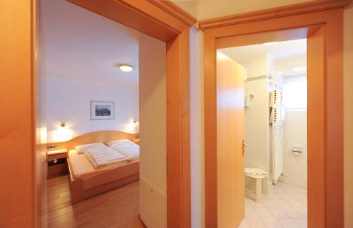 a small bedroom with a bed and a bathroom at Pension Panorama in Solda