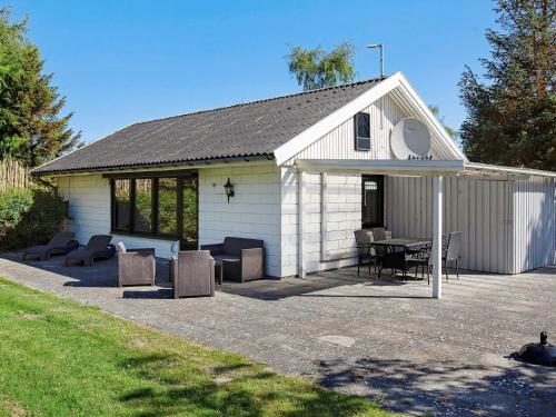 a white shed with a table and chairs in it at 6 person holiday home in Gedser in Gedser