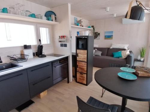 eine Küche und ein Wohnzimmer mit einem Tisch und einer Couch in der Unterkunft BUQEZ Villa 30 "Beachvilla Stella" mit SPA & Meerblick in Drage