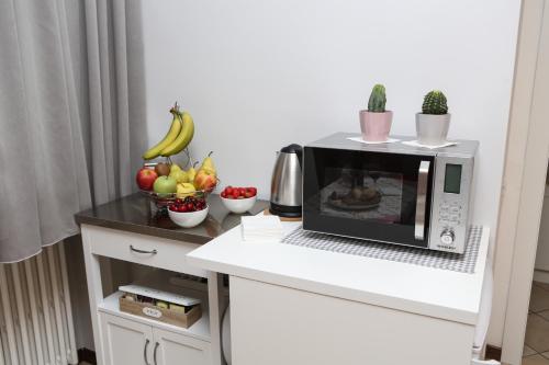 a microwave on a counter with fruits and vegetables at La casa di Ada in Sondrio