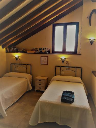 two beds in a room with a window at Cortijo Don Enrique in Restábal