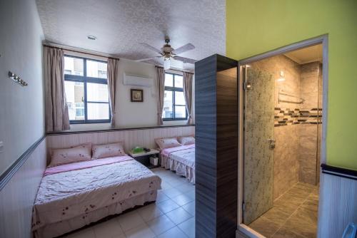 a bedroom with two beds and a shower in it at For you Bed and Breakfast in Magong